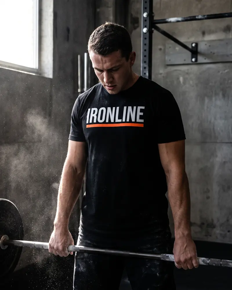 Athlete in an IRONLINE shirt lifting a barbell